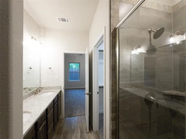 a bathroom with a granite countertop sink shower and a mirror