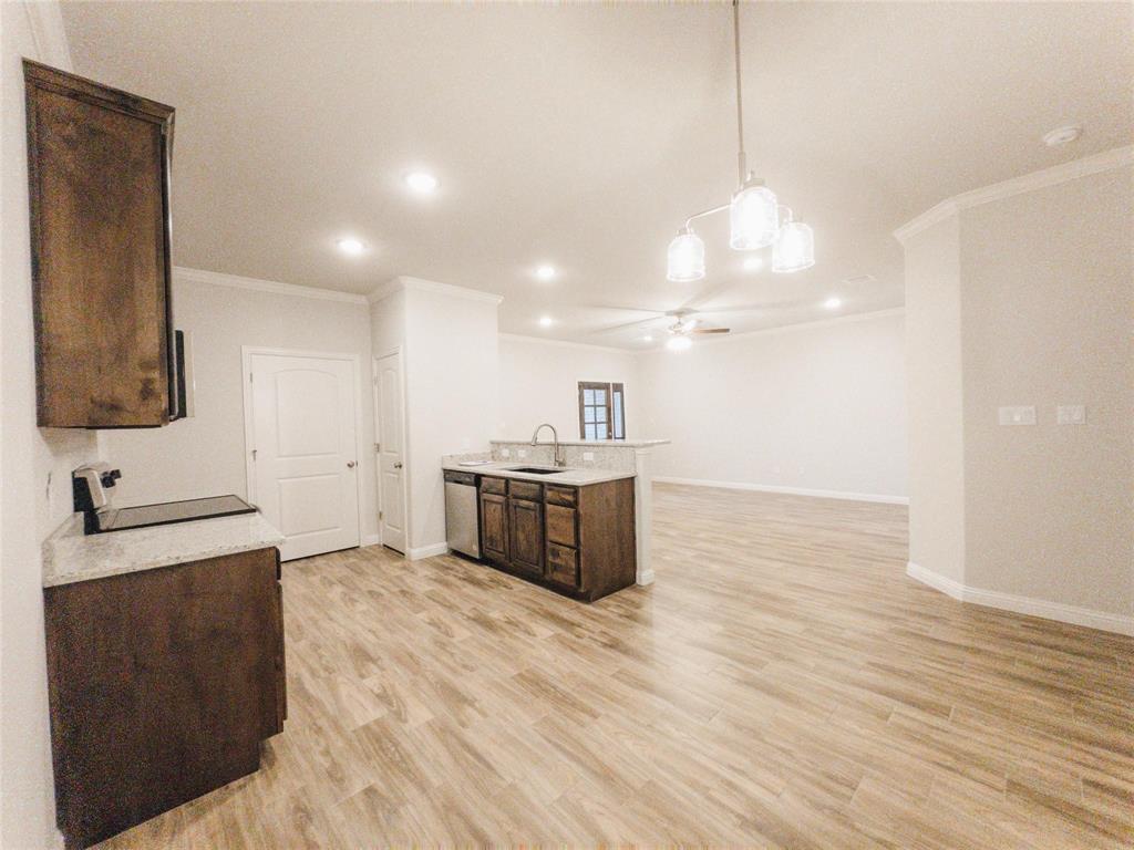 245 Honor Code Place Granbury, TX 76049 - Photo 4 of 16 a kitchen with stainless steel appliances granite countertop a sink cabinets and wooden floor