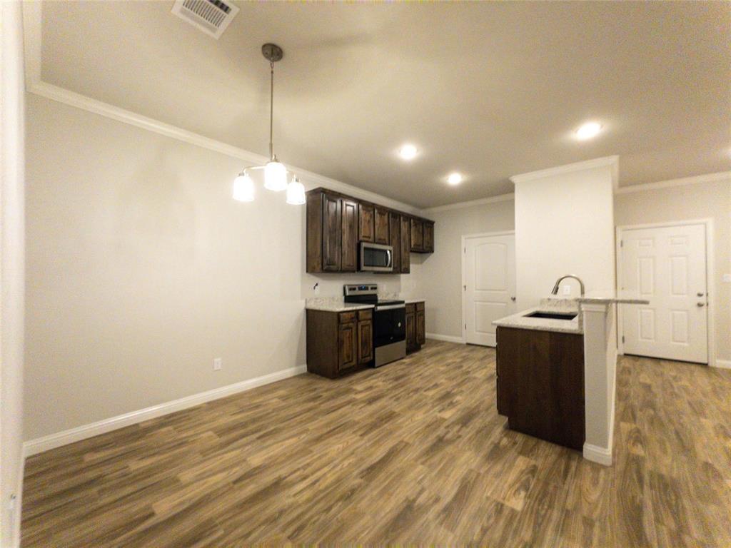 245 Honor Code Place Granbury, TX 76049 - Photo 5 of 16 a kitchen with kitchen island a counter top space a sink and stainless steel appliances
