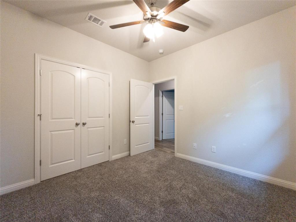 245 Honor Code Place Granbury, TX 76049 - Photo 9 of 16 an empty room with closet and a chandelier fan