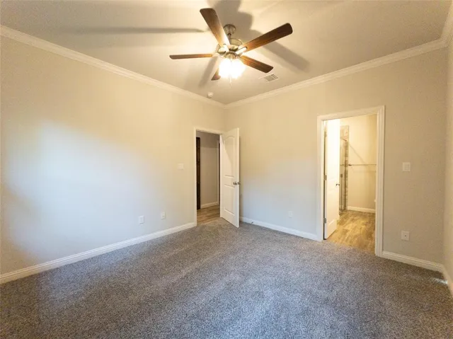 an empty room with closet and a ceiling fan