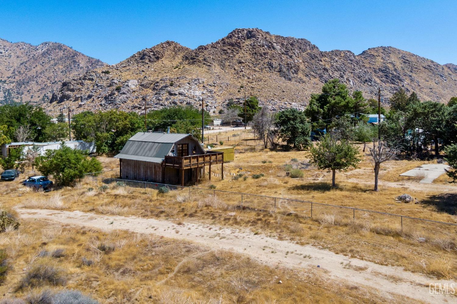 Undisclosed Address Onyx, CA 93255 - Photo 3 of 18 a view of a dry yard with mountains in the background