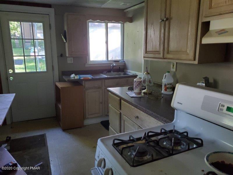 828 Toll Road Effort, PA 18330 - Photo 3 of 8 a kitchen with a stove and a wooden floor