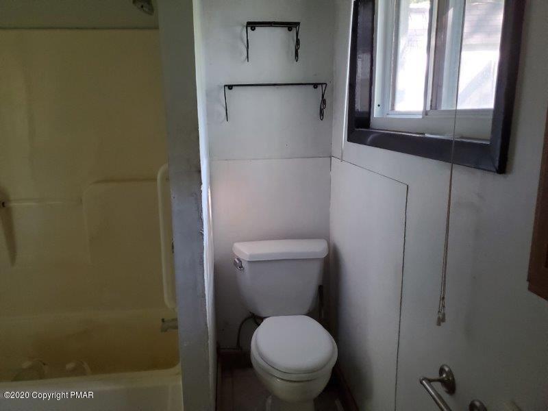828 Toll Road Effort, PA 18330 - Photo 5 of 8 a white toilet sitting in a bathroom next to a window