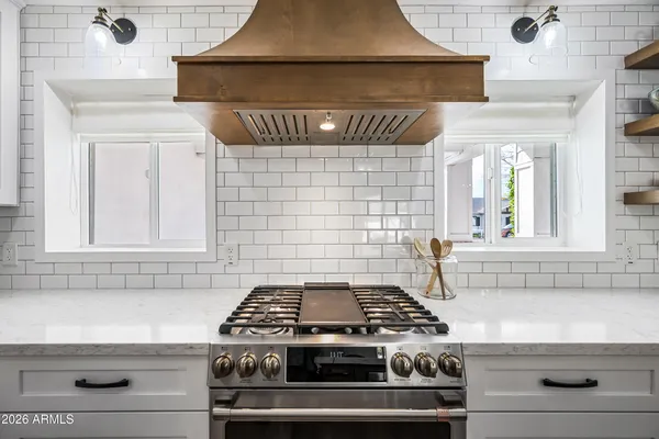 a kitchen with stainless steel appliances a stove a sink and white cabinets