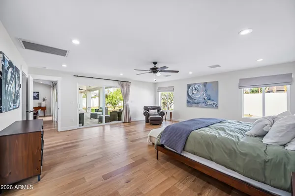 a bedroom with a bed and furniture with wooden floor