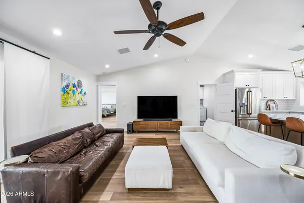 a living room with furniture kitchen view and a window
