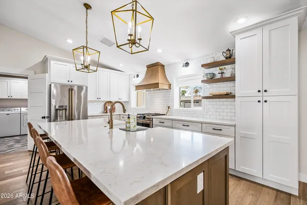 a kitchen with kitchen island granite countertop a sink a center island and stainless steel appliances
