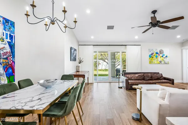 a view of a dining room with furniture a rug and wooden floor