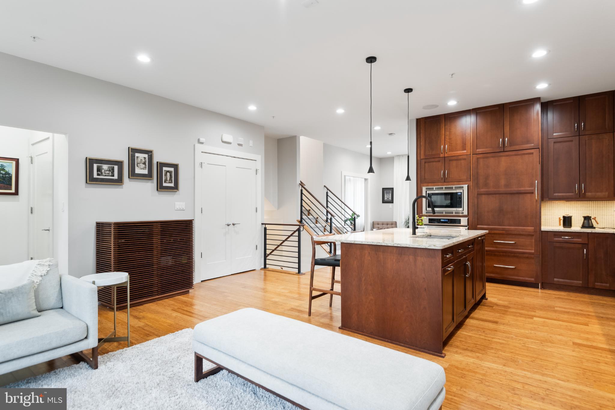 5117 Willet Bridge Road Bethesda, MD 20816 - Photo 15 of 46 a large kitchen with stainless steel appliances kitchen island granite countertop a refrigerator a stove a sink a dining table and chairs with wooden floor