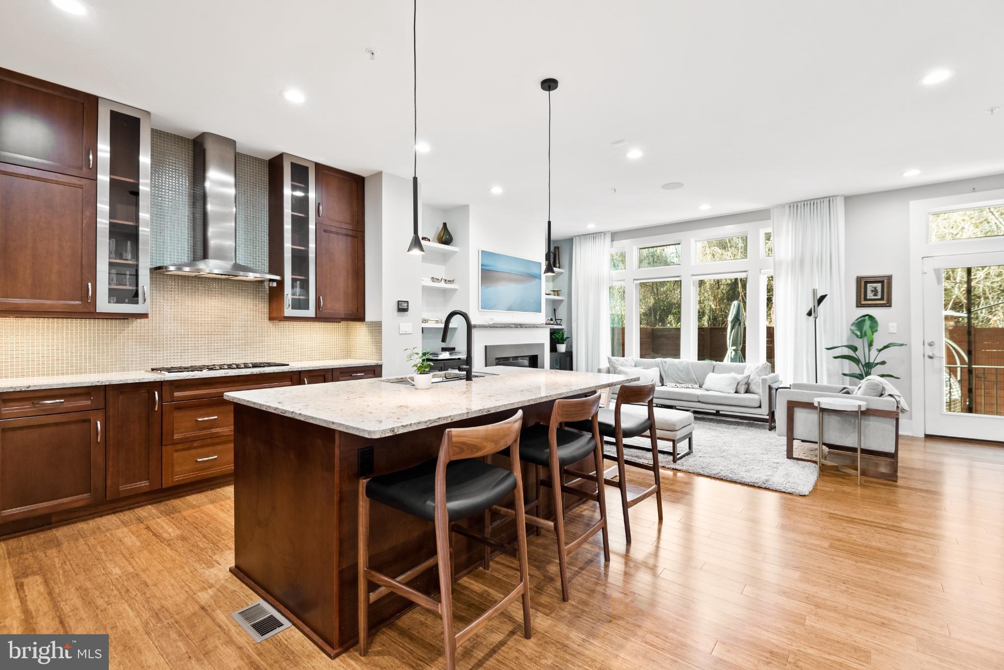 5117 Willet Bridge Road Bethesda, MD 20816 - Photo 18 of 46 a kitchen with granite countertop a stove a sink a dining table and chairs with wooden floor
