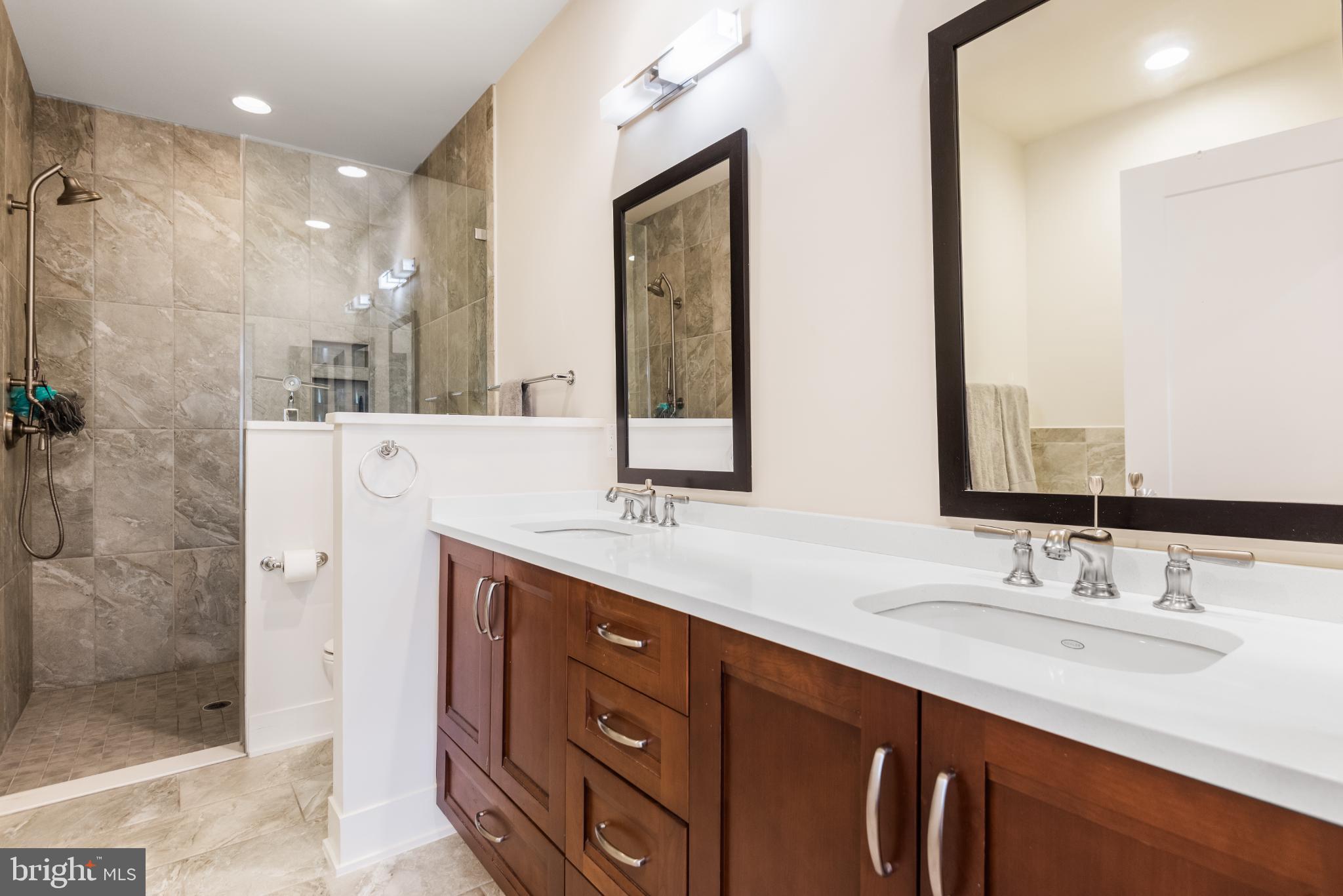 5117 Willet Bridge Road Bethesda, MD 20816 - Photo 30 of 46 a bathroom with a double vanity sink mirror and shower