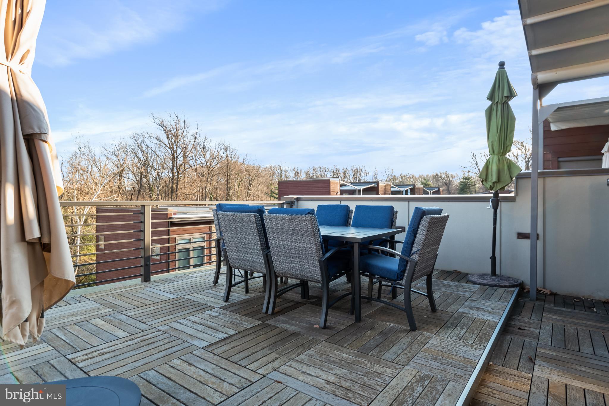 5117 Willet Bridge Road Bethesda, MD 20816 - Photo 41 of 46 a view of a roof deck with table and chairs a barbeque with wooden floor and fence