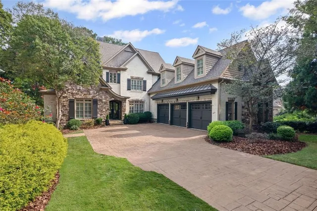 a front view of a house with a yard and potted plants