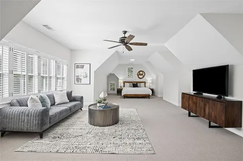 an aerial view of a house with yard and trees in the background