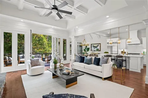 a dining room with wooden floor a chandelier a wooden table and chairs