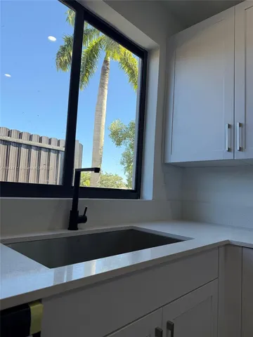 a kitchen with granite countertop a refrigerator stove top oven and sink