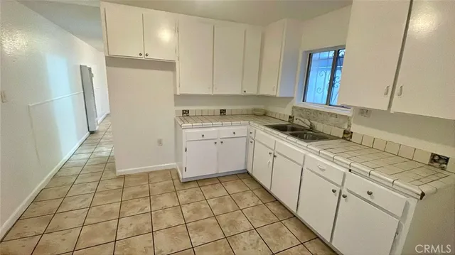 a kitchen with a sink a stove a refrigerator and cabinets