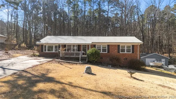 a view of house with yard outdoor seating and barbeque oven