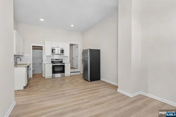 a open kitchen with white cabinets and stainless steel appliances