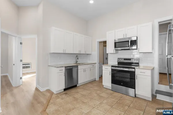 a kitchen with a stove top oven and refrigerator