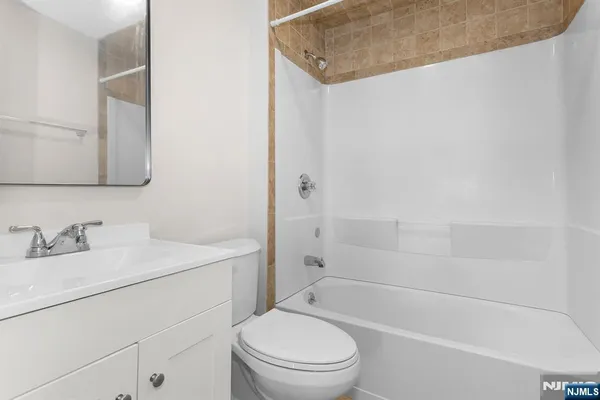 a bathroom with a granite countertop sink a toilet and shower
