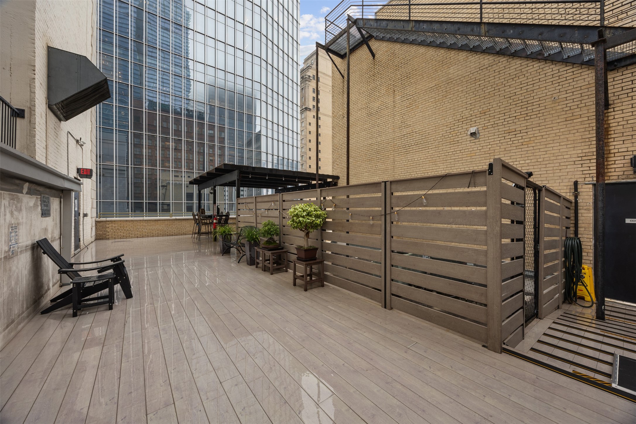 705 Main Street, Unit 513 Houston, TX 77002 - Photo 13 of 22 a view of a patio with table and chairs with wooden floor and fence