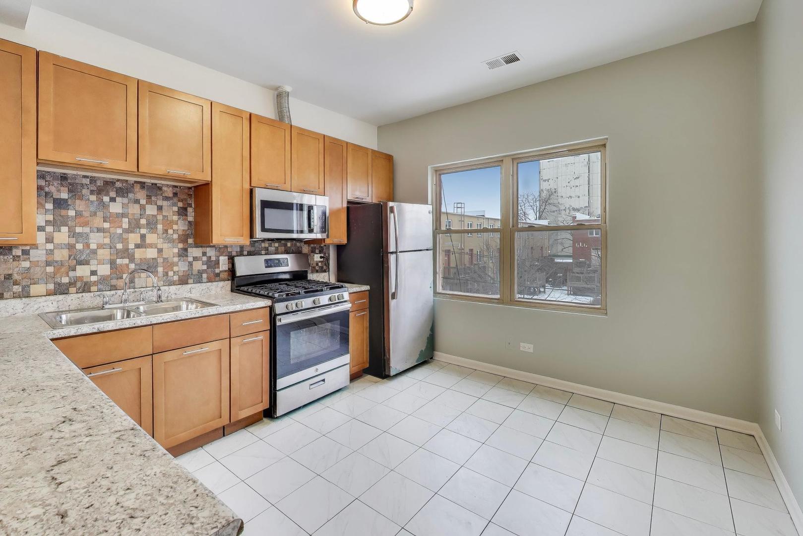 5938 South Indiana Avenue, Unit 2 Chicago, IL 60637 - Photo 7 of 17 a kitchen with stainless steel appliances granite countertop a stove a sink and a microwave