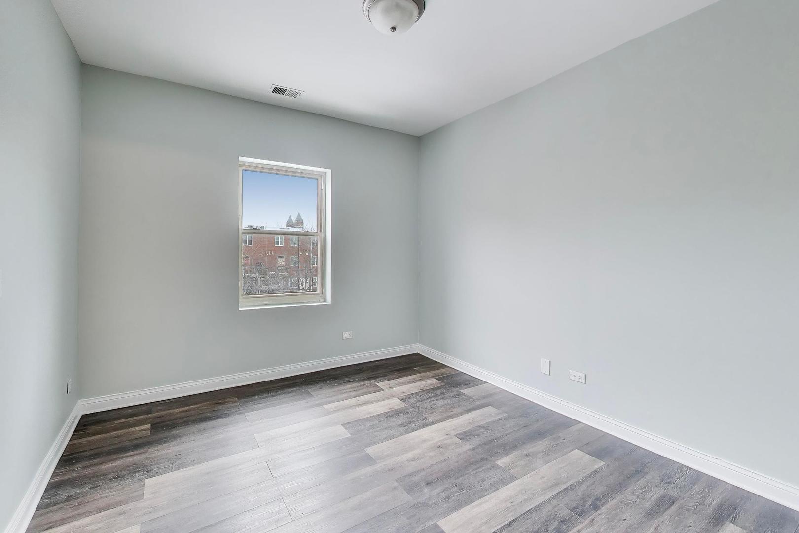 5938 South Indiana Avenue, Unit 2 Chicago, IL 60637 - Photo 9 of 17 a view of an empty room with wooden floor and a window