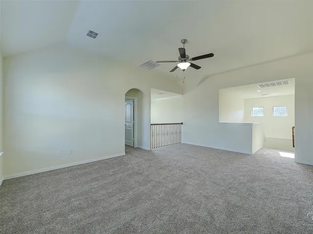 an empty room with fan and windows