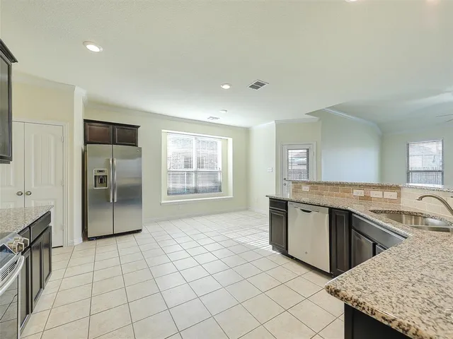 a large kitchen with a stove a sink dishwasher and a refrigerator