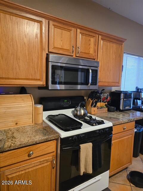 5301 West Grenadine Road Laveen, AZ 85339 - Photo 14 of 37 a kitchen with granite countertop a stove top oven microwave and cabinets