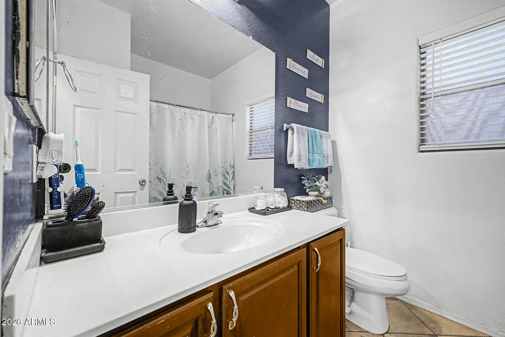 5301 West Grenadine Road Laveen, AZ 85339 - Photo 23 of 37 a bathroom with a sink a toilet and mirror