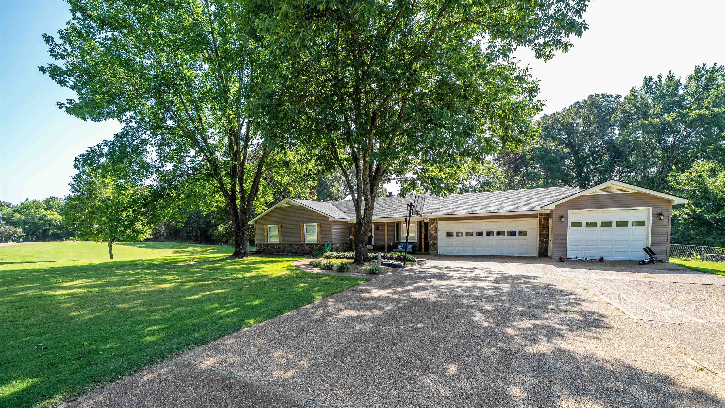 a front view of a house with a yard and trees