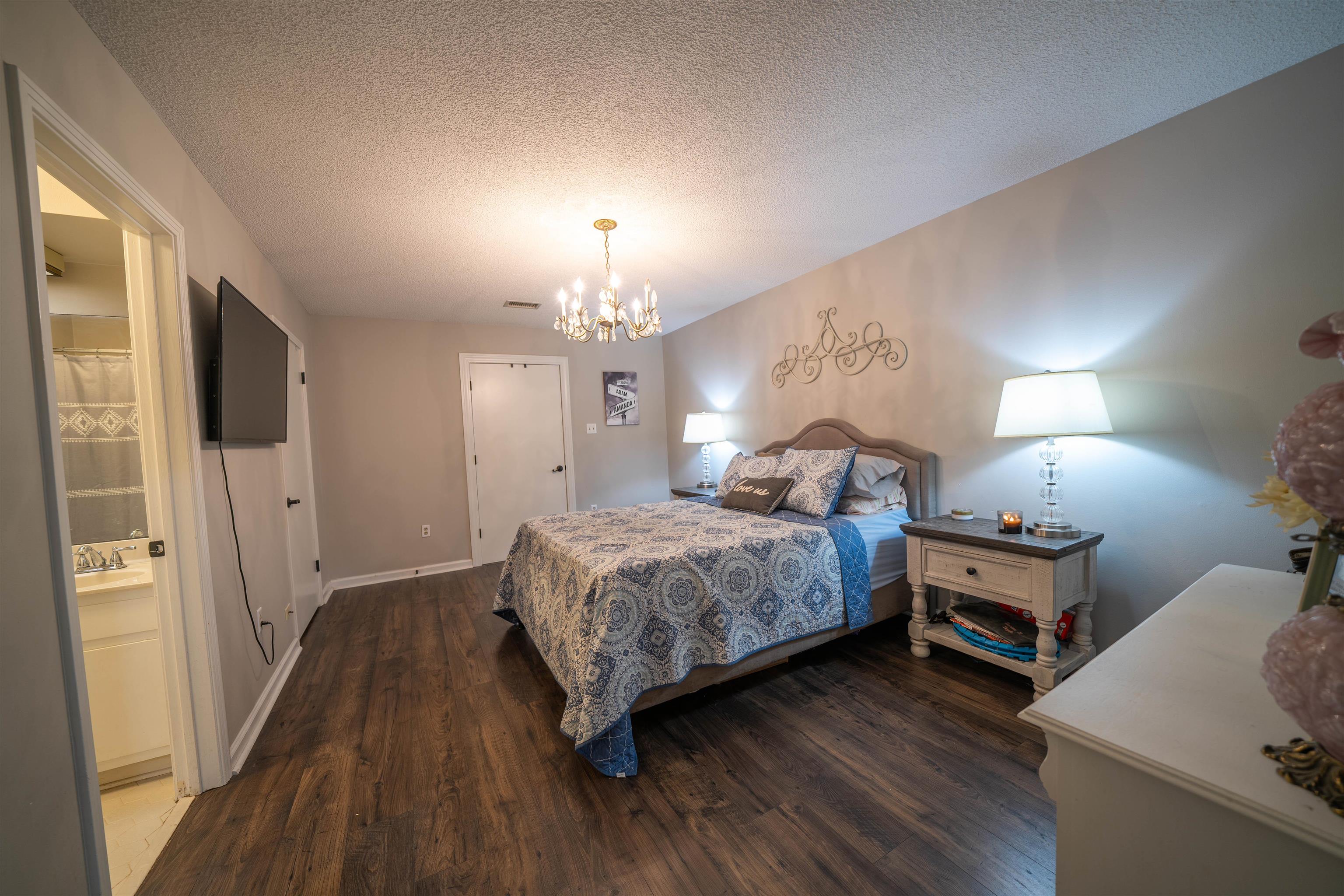 285 Woodbridge Road Somerville, TN 38068 - Photo 12 of 24 a spacious bedroom with a bed and a chandelier