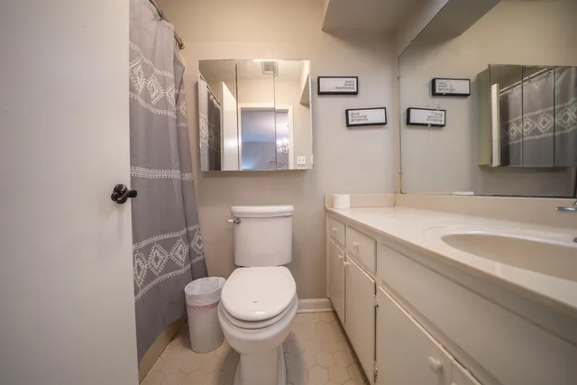 a bathroom with a granite countertop toilet sink and mirror
