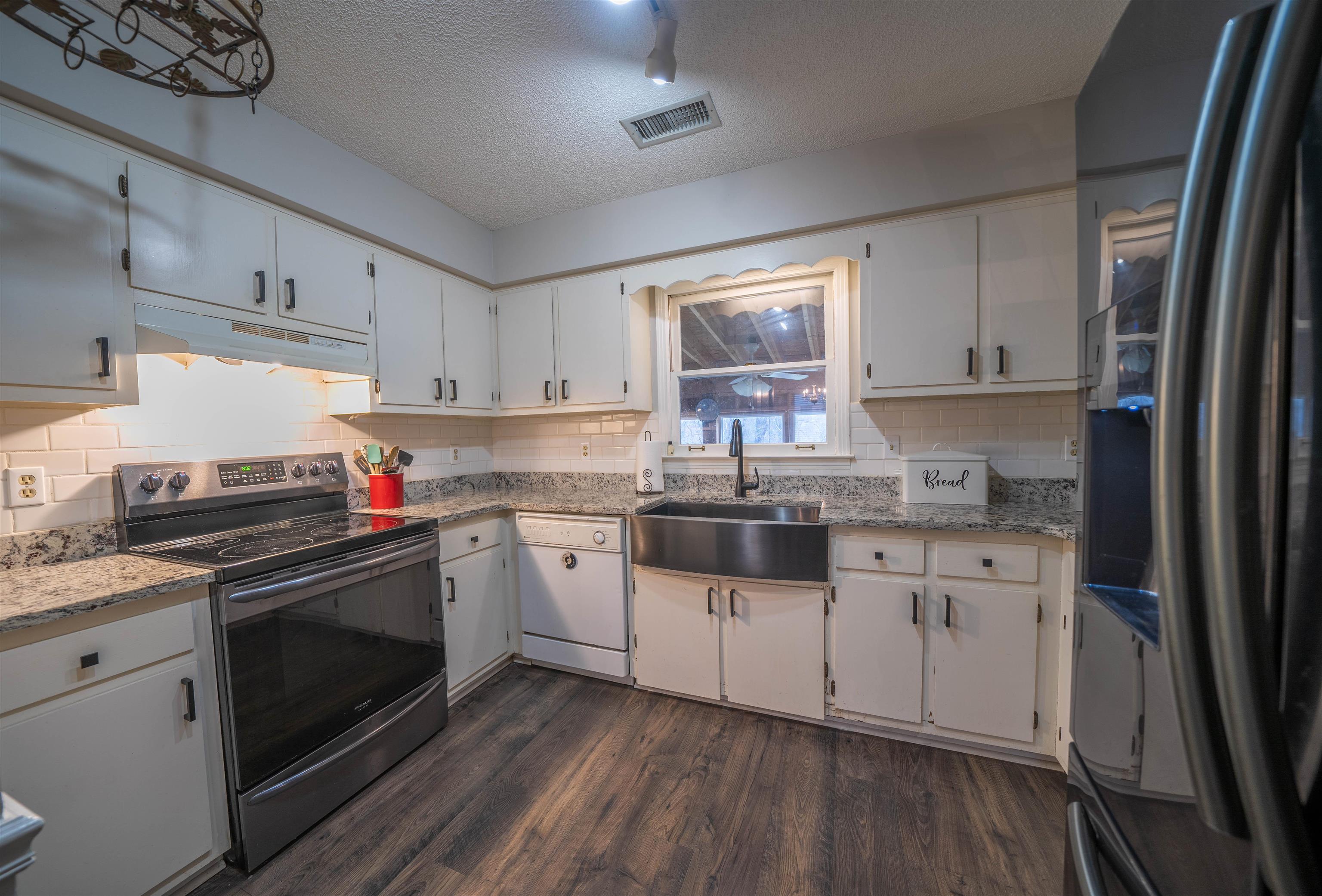 285 Woodbridge Road Somerville, TN 38068 - Photo 2 of 24 a kitchen with granite countertop white cabinets and white appliances