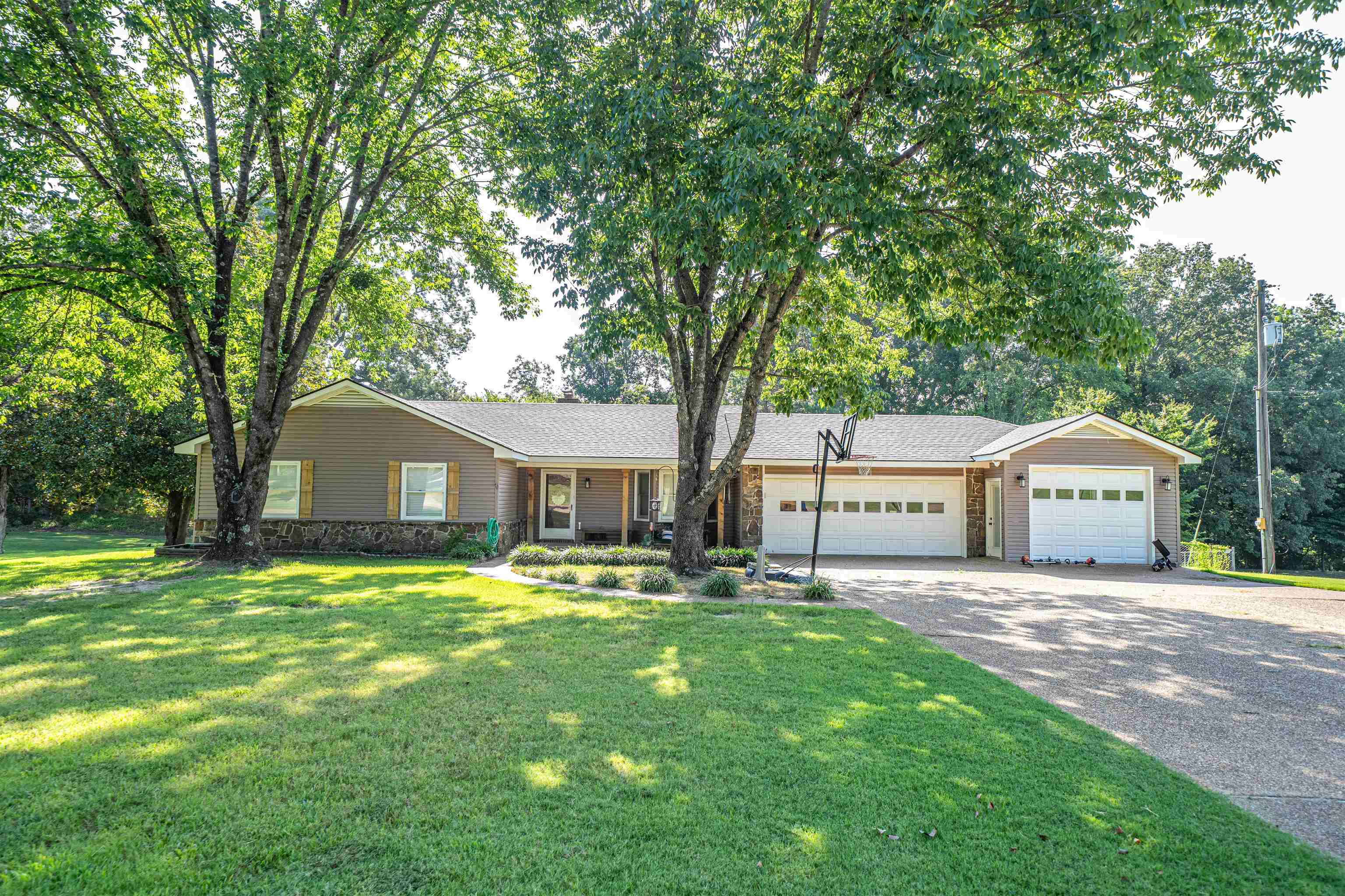 285 Woodbridge Road Somerville, TN 38068 - Photo 21 of 24 a front view of a house with a garden and trees