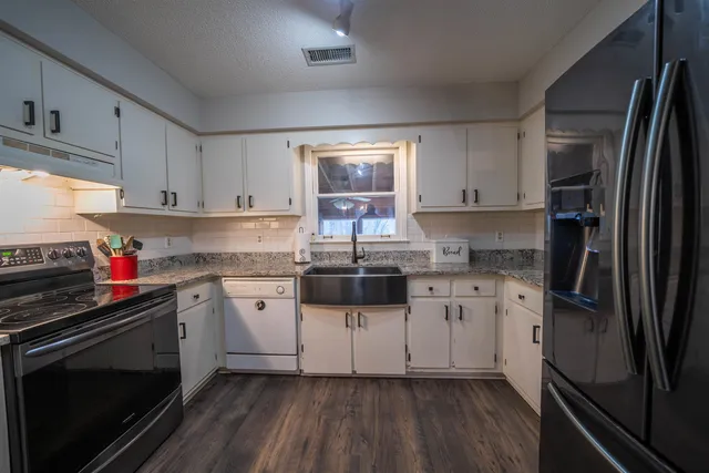 a kitchen with a stove a sink and a refrigerator