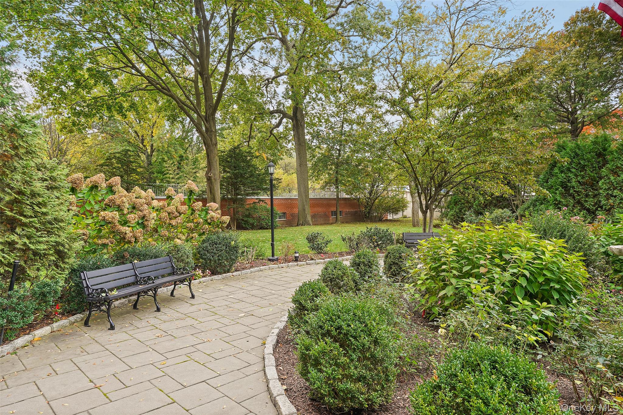 900 Palmer Road, Unit 5A Bronxville, NY 10708 - Photo 14 of 15 a garden with trees in front of it