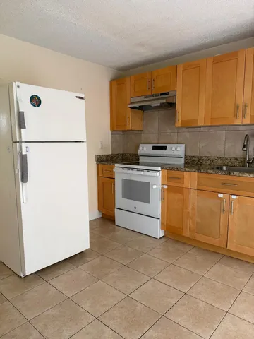 a kitchen with cabinets and white stainless steel appliances