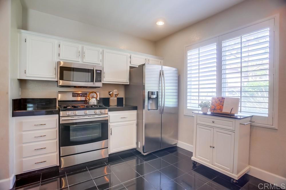 6094 Citracado Circle Carlsbad, CA 92009 - Photo 14 of 47 a kitchen with stainless steel appliances white cabinets and a refrigerator