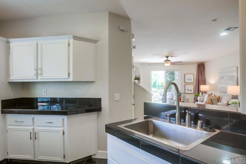 6094 Citracado Circle Carlsbad, CA 92009 - Photo 17 of 47 a kitchen with granite countertop a sink a stove and cabinets