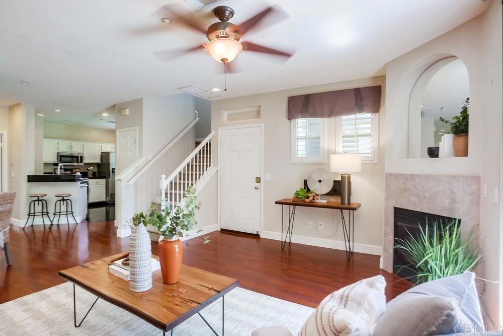 6094 Citracado Circle Carlsbad, CA 92009 - Photo 8 of 47 a living room with furniture a fireplace and a chandelier
