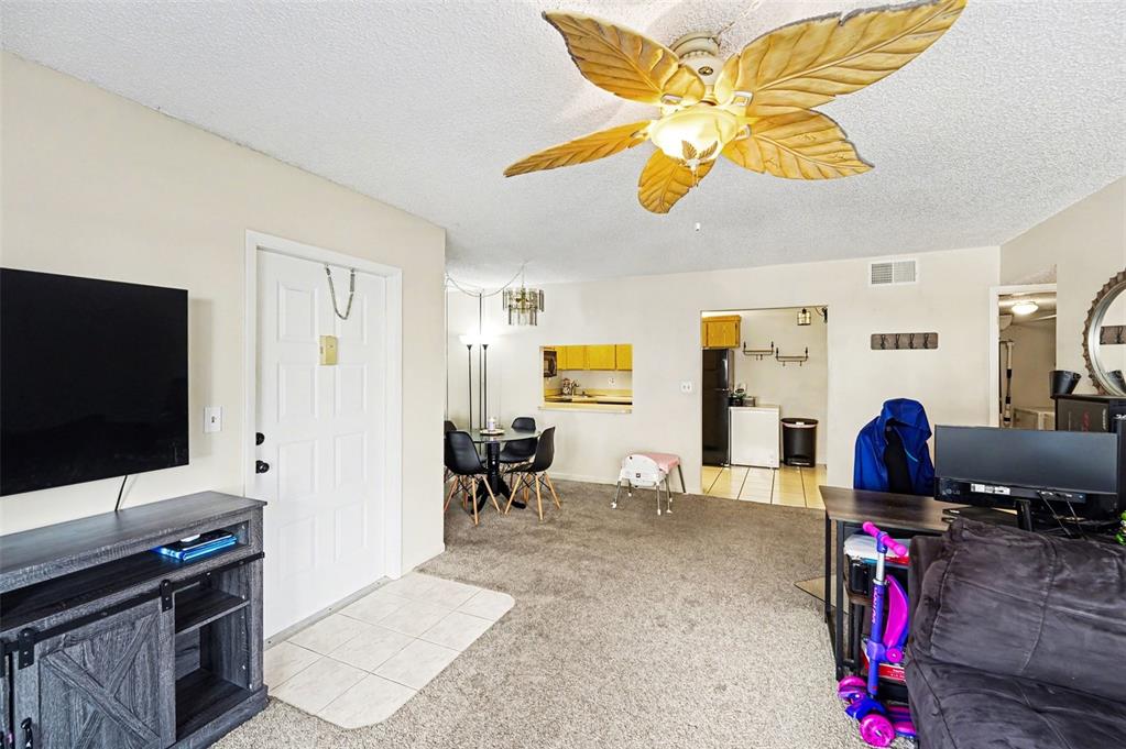1261 Pine Ridge Circle West, Unit D1 Tarpon Springs, FL 34688 - Photo 4 of 14 a living room with furniture and a flat screen tv