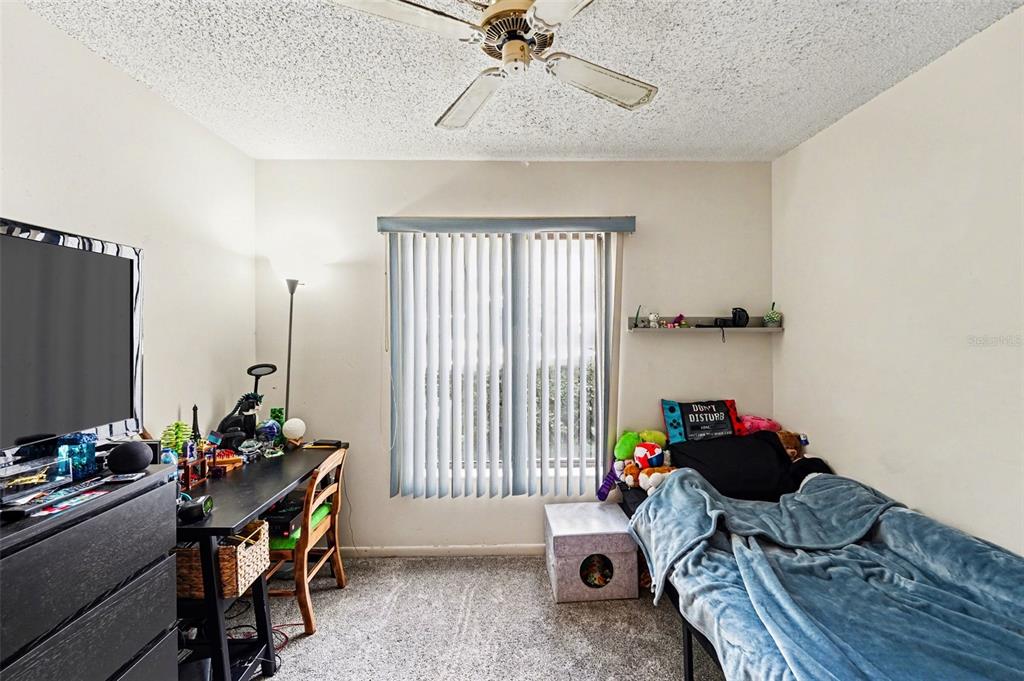 1261 Pine Ridge Circle West, Unit D1 Tarpon Springs, FL 34688 - Photo 7 of 14 a bedroom with a workspace