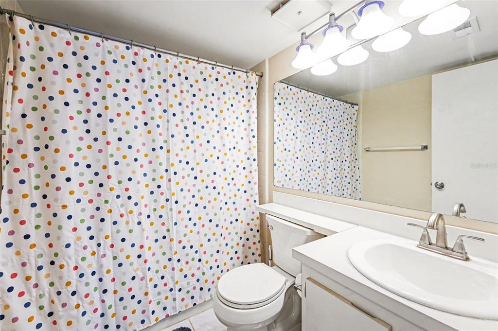 1261 Pine Ridge Circle West, Unit D1 Tarpon Springs, FL 34688 - Photo 8 of 14 a bathroom with a sink a toilet a shower and a mirror