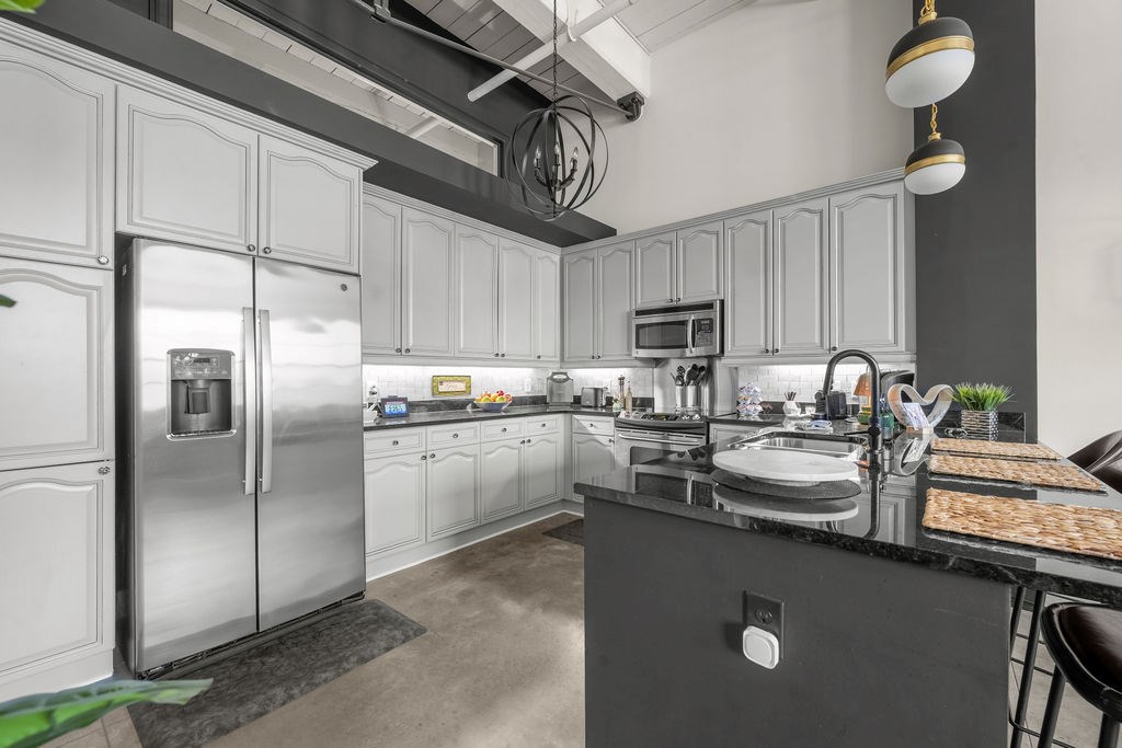 1201 Front Avenue, Unit 322 Columbus, GA 31901 - Photo 6 of 54 a kitchen with stainless steel appliances granite countertop a sink a stove a refrigerator cabinets and chairs
