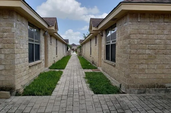 a pathway of a house with a yard
