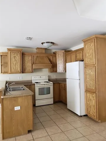 a kitchen with a refrigerator sink stove and cabinets